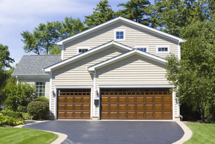 large suburban home with asphalt driveway lined with cement block