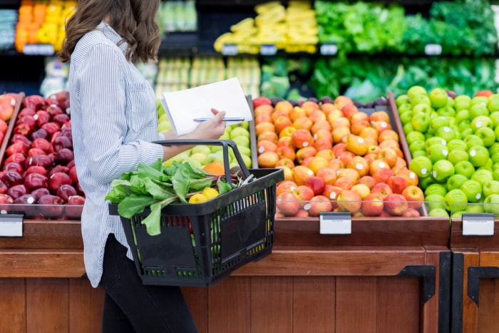 façons d'économiser de l'argent à la maison - une femme fait ses courses avec une liste