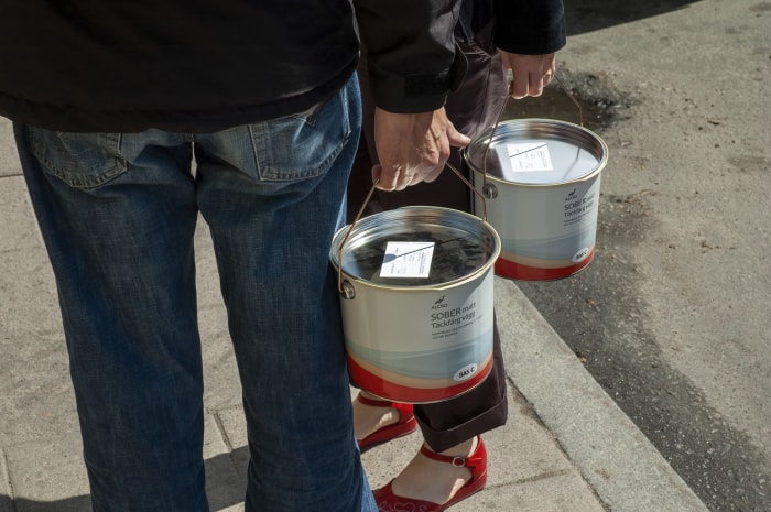 deux personnes transportent chacune un pot de peinture