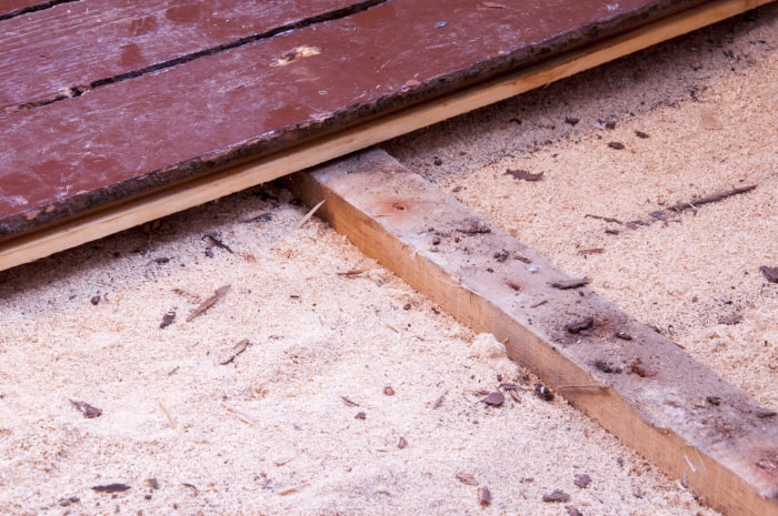 L'isolant en sciure de bois sous les planches de plancher présente une certaine dépression (affaissement) au fil du temps.