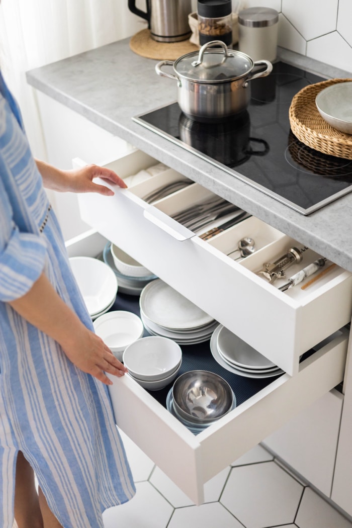 femme tirant des tiroirs dans la cuisine