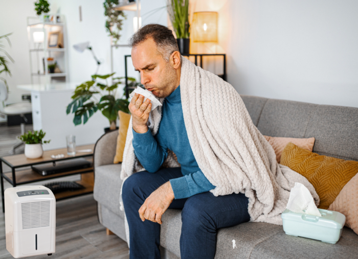 Un homme éternue dans sa maison