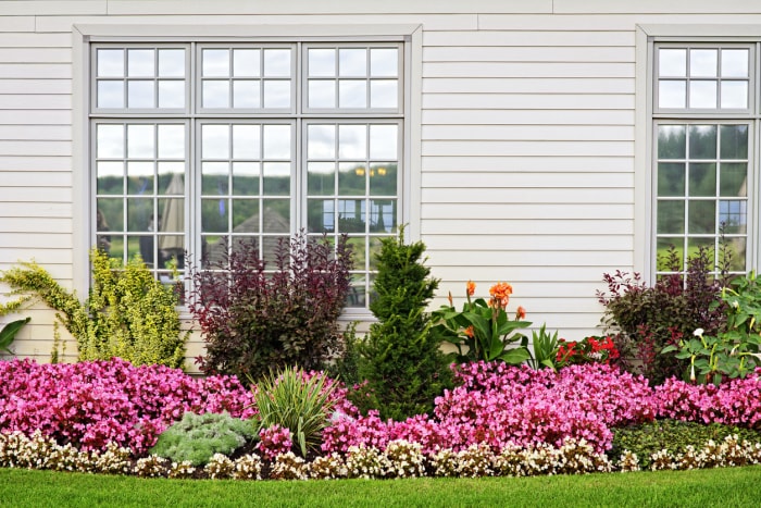 side of house with brightly colored flower bed lining the wall