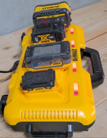 La station de charge Dewalt avec plusieurs batteries d'outils électriques branchées pour le chargement.