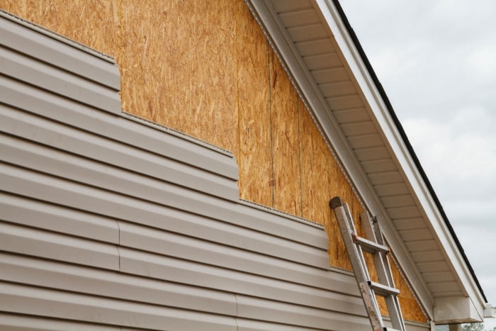 Gros plan d'un nouveau revêtement en cours d'installation sur une maison. 