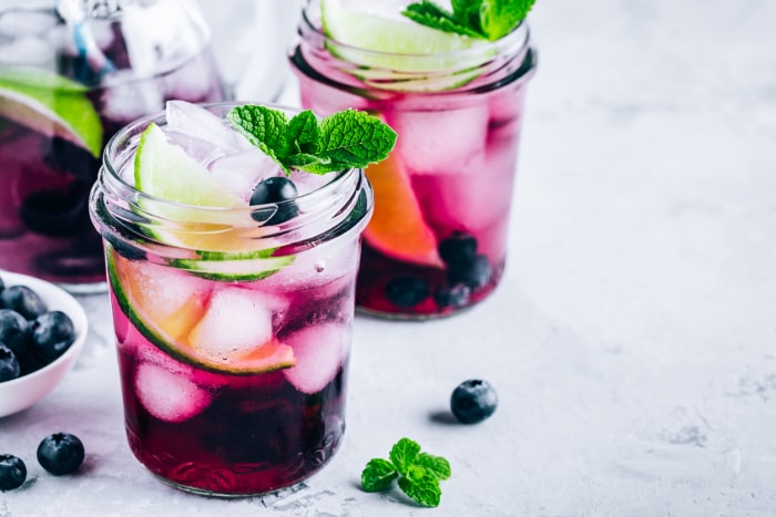 Mojito aux myrtilles, citron vert et menthe fraîche. Boissons d'été glacées dans un bocal en verre.