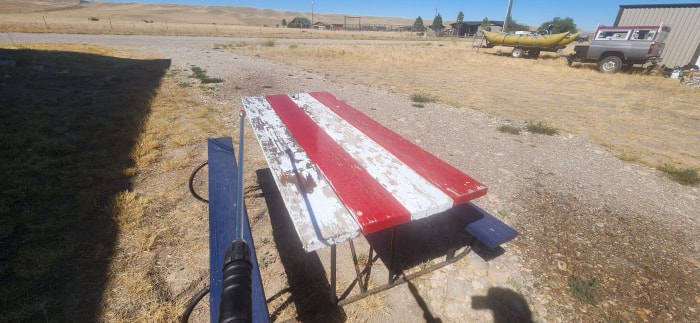 Photo d'une table de pique-nique en train d'être lavée sous pression