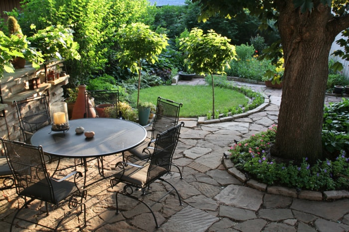 Patio arrière paysager, jardin fleuri avec pavés naturels