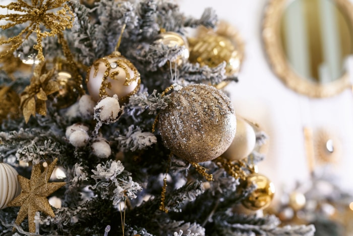 vue rapprochée d'un arbre de Noël avec des ornements dorés et des branches givrées