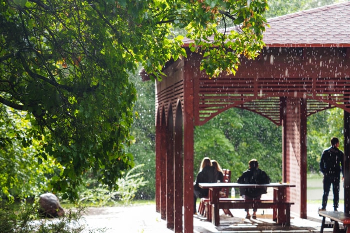 Personnes se cachant de la pluie dans un gazebo