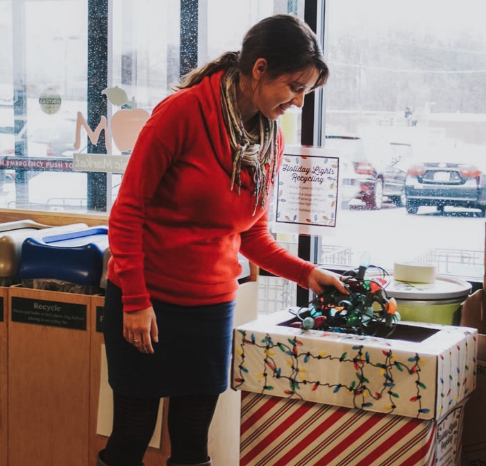 Une femme recycle des guirlandes de Noël au marché bio de Mom's