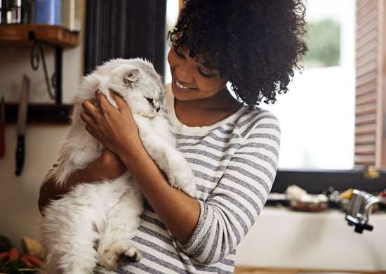 Femme tenant un chat dans la buanderie