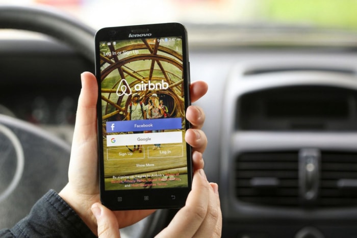 Gros plan sur l'écran d'un smartphone affichant la page web d'Airbnb. 