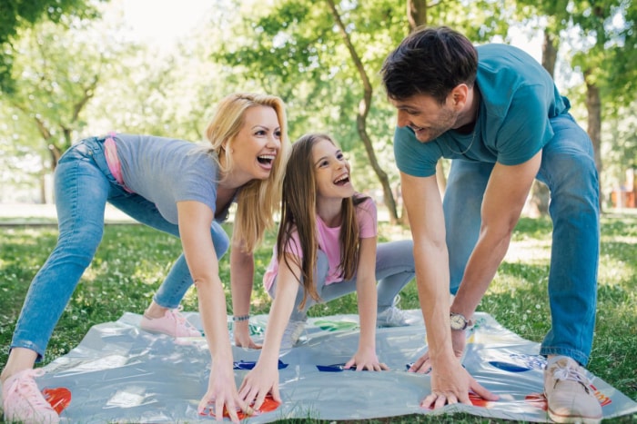 Famille jouant au Twister en plein air.