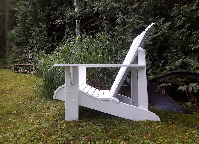 Vue latérale d'une chaise Adirondack blanche à profil bas