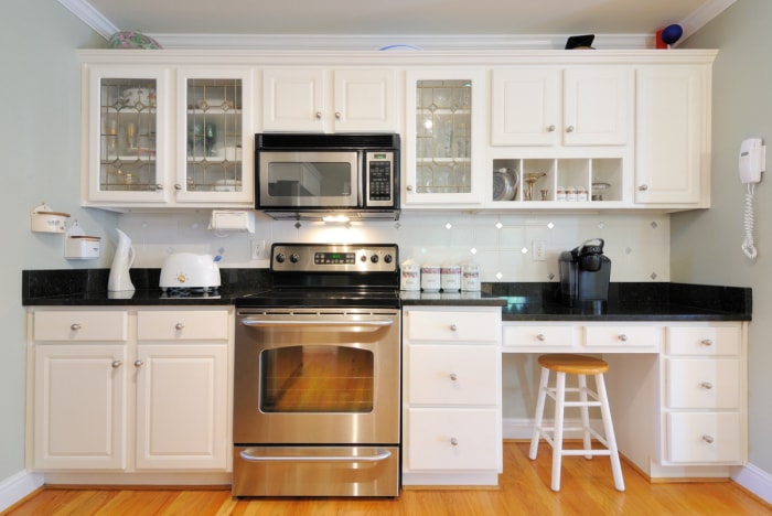 Cuisine blanche avec micro-ondes sur cuisinière.