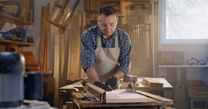 film de sécurité pour fenêtre homme dans un atelier avec des outils fenêtre derrière