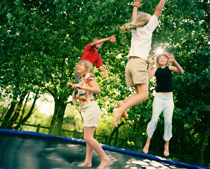 Quatre enfants sautant sur un trampoline extérieur