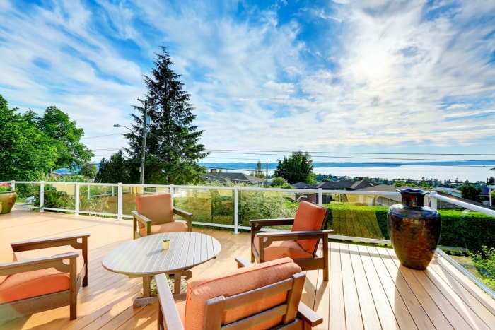 Une terrasse avec des meubles de jardin et une vue sur le lac.