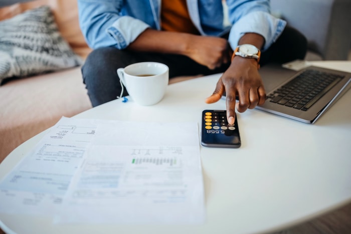 iStock-1359420140 Rabais et crédits d'impôt Homme faisant ses impôts avec une calculatrice et un ordinateur.jpg