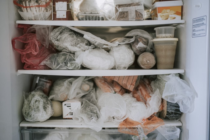 congélateur supérieur rempli de paquets emballés dans du plastique et du papier de congélation