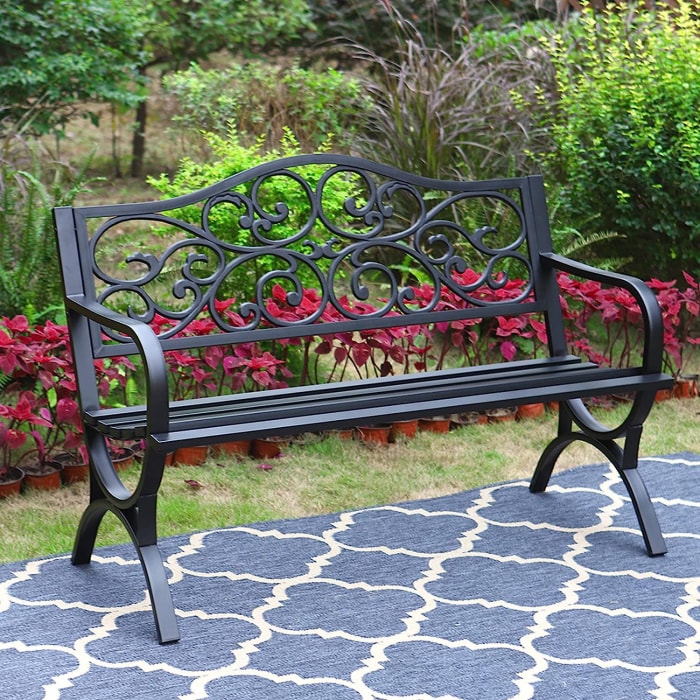 Banc de jardin classique en fonte sur un tapis d'extérieur géométrique.