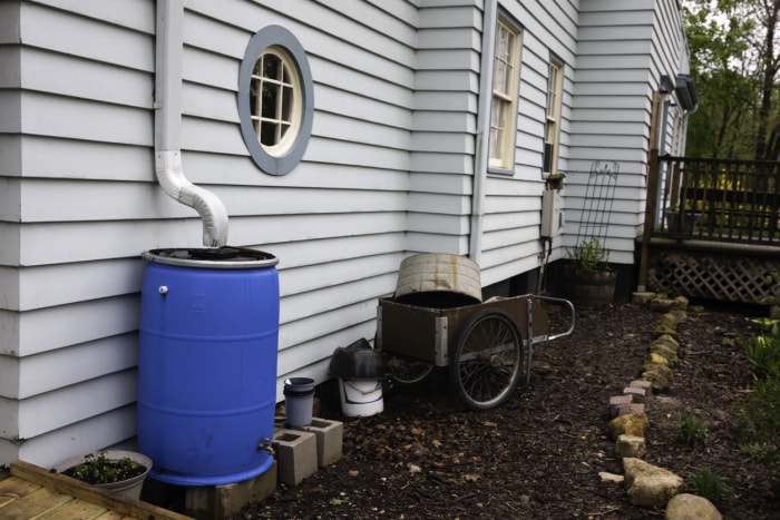 Baril de pluie bleu sur le côté de la maison