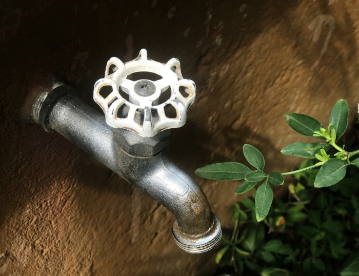 Un robinet extérieur sur une maison.