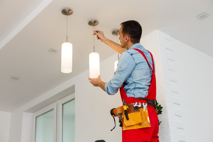 iStock-1263134450 déclarations de revenus améliorations domiciliaires électricien homme ouvrier installant un plafonnier