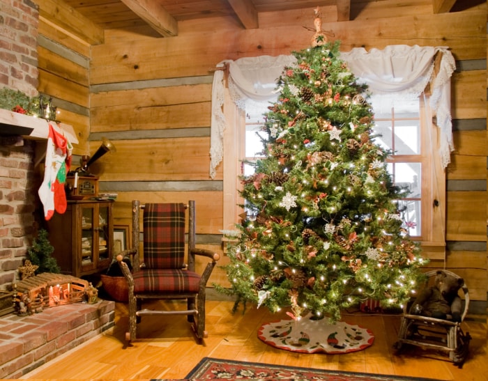 Un-arbre-de-Noël-décoré-de-cônes-de-pin-et-d'autres-éléments-naturels-dans-un-log-cabin.