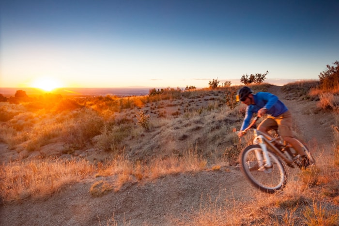 iStock-495751190 les endroits les moins chers pour acheter de la terre homme à vélo au coucher du soleil près d'albequrque new mexico