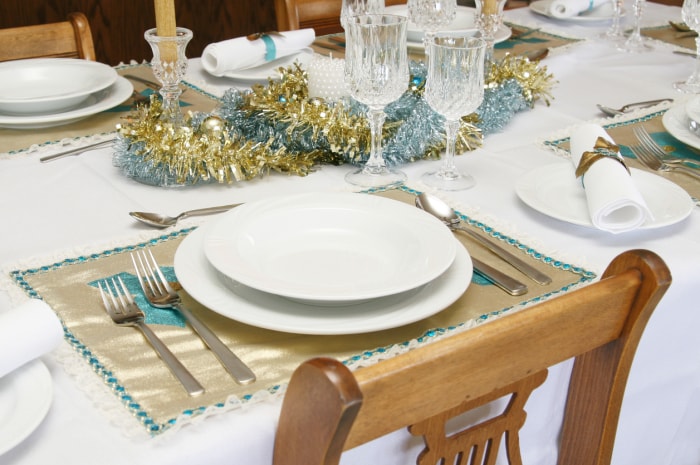 Table dressée pour le dîner avec des guirlandes au milieu en guise de chemin de table.