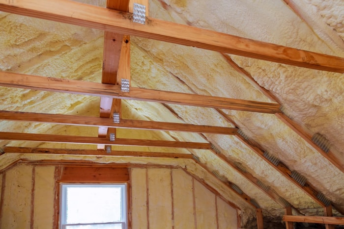 Isolation en mousse pulvérisée installée dans le grenier d'une maison pour en améliorer l'efficacité énergétique.