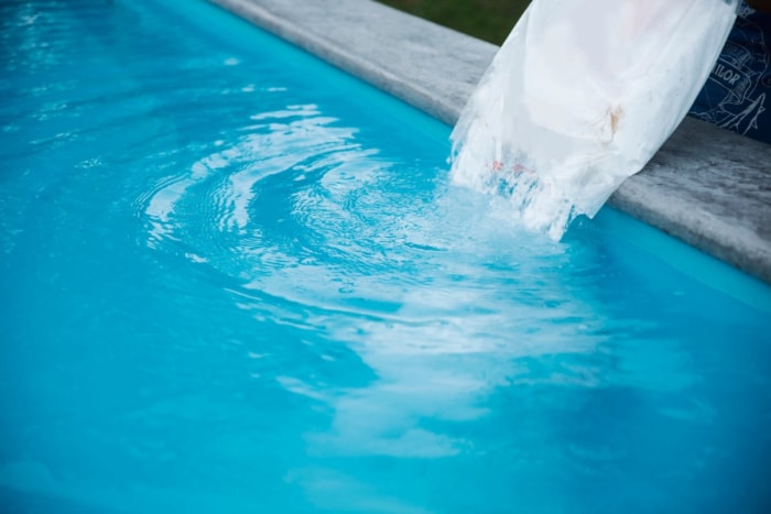 Gros plan sur une solution versée dans une piscine. 