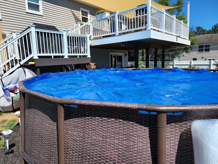 Piscine hors sol avec une couverture de piscine bleue sur le dessus