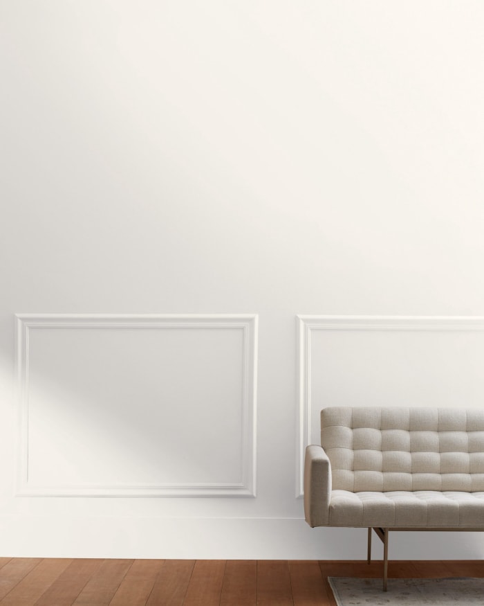 Pièce minimale avec un petit canapé, peinte en Atrium White de Benjamin Moore.