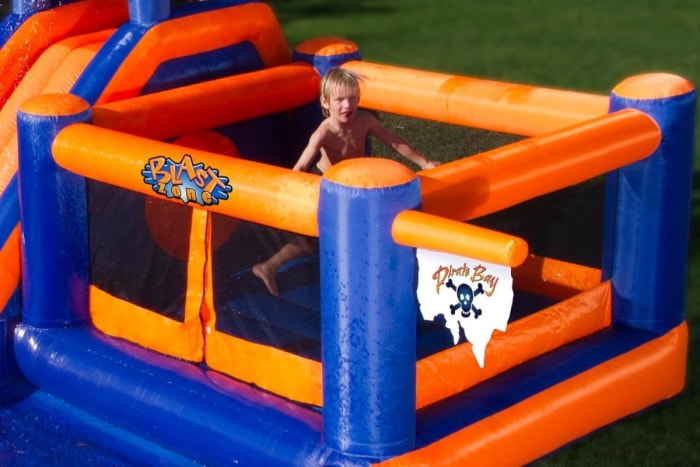 Un jeune garçon jouant dans un toboggan aquatique gonflable