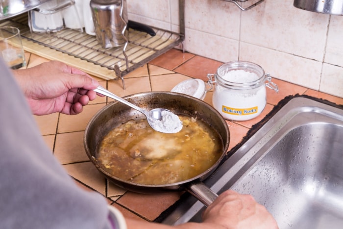 Saupoudrer du bicarbonate de soude dans une poêle brûlée