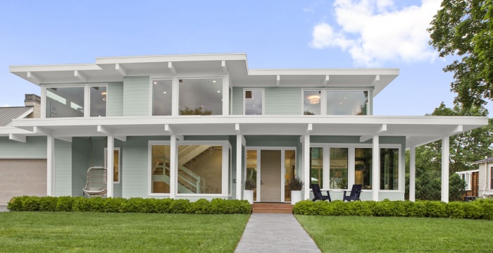 Une maison moderne est peinte en bleu pâle avec des bordures blanches.