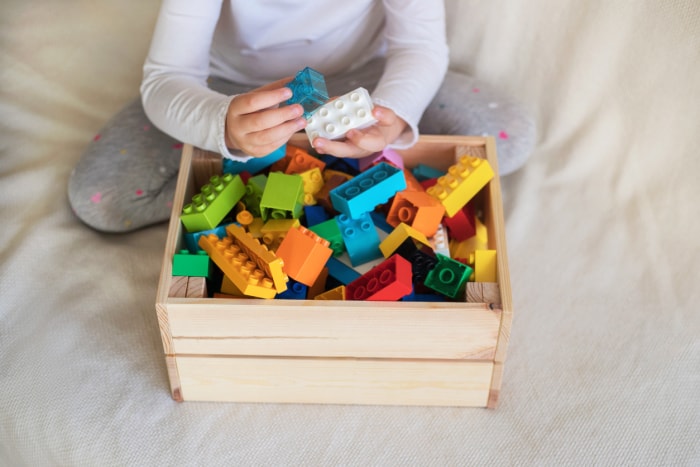 14 choses que vous ne saviez pas que vous pouviez nettoyer dans votre machine à laver enfant triant des briques de lego dans une caisse