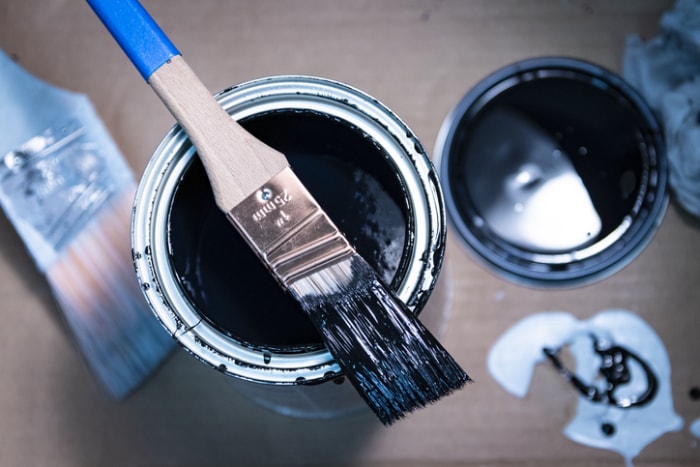 deux-boîtes-de-peinture-avec-bleu-peine-à-l'intérieur-sous-un-brusch-de-peine-et-sur-une-table-en-bois