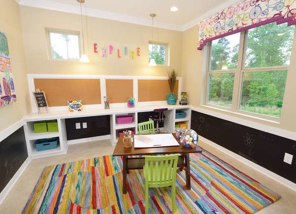 salle de jeux pour enfants avec tapis coloré et table à taille enfant