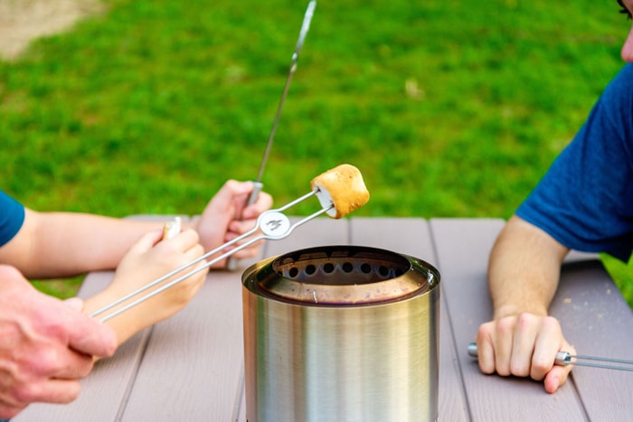 Des enfants font griller des guimauves avec les mini-bâtonnets à rôtir en acier inoxydable qui font partie du kit d'accessoires Solo Stove Mesa XL