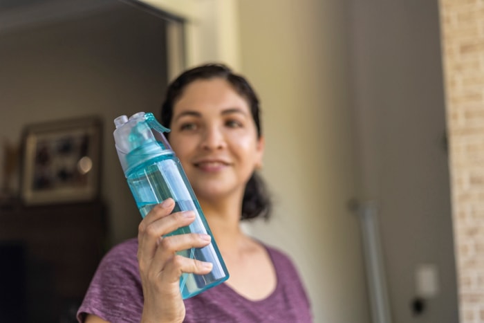 Femme tenant une bouteille en plastique réutilisable