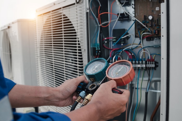 Un technicien mesure un climatiseur.