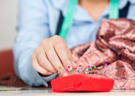 Gros plan d'une femme utilisant un coussin à épingles