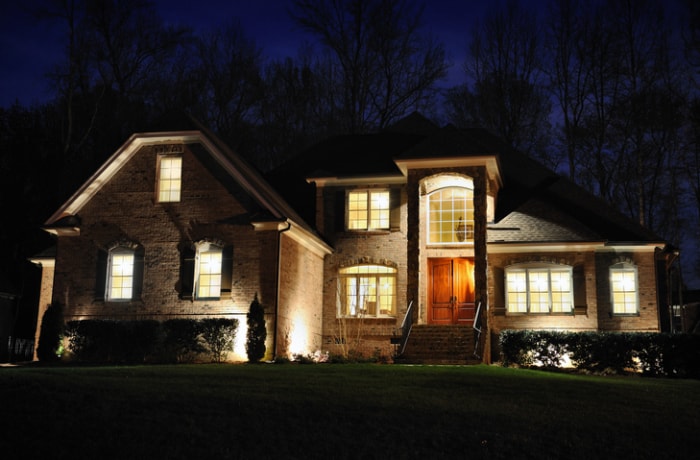 éclairage-de-paysage-maison-à-deux-étages-la-nuit-avec-éclairage-sur-la-facade