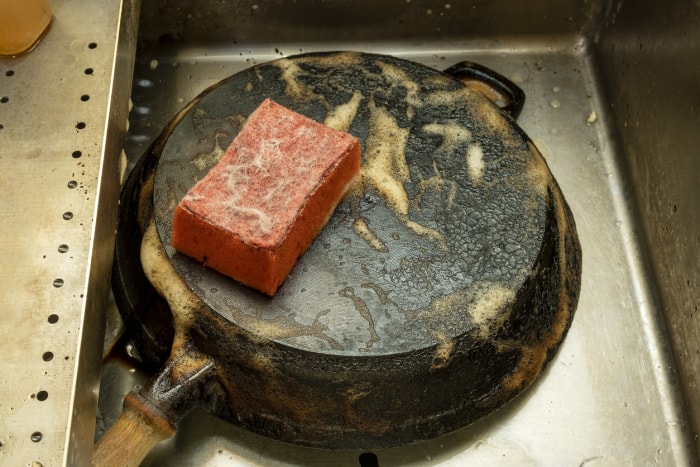 Frotter une poêle en fonte avec une éponge rouge et verser la soupe.