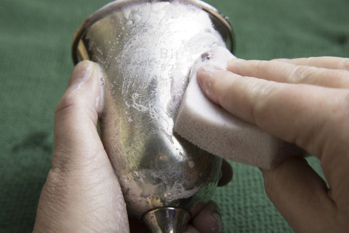 Polir à la main le verre en argent avec un nettoyant pour argent et une éponge.