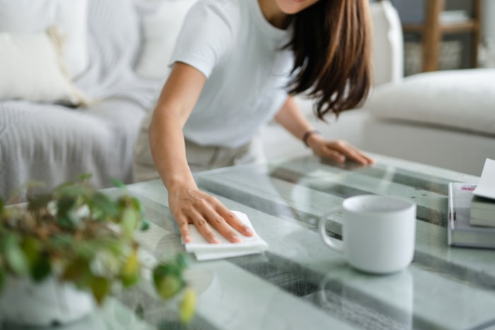 femme époussetant une table basse